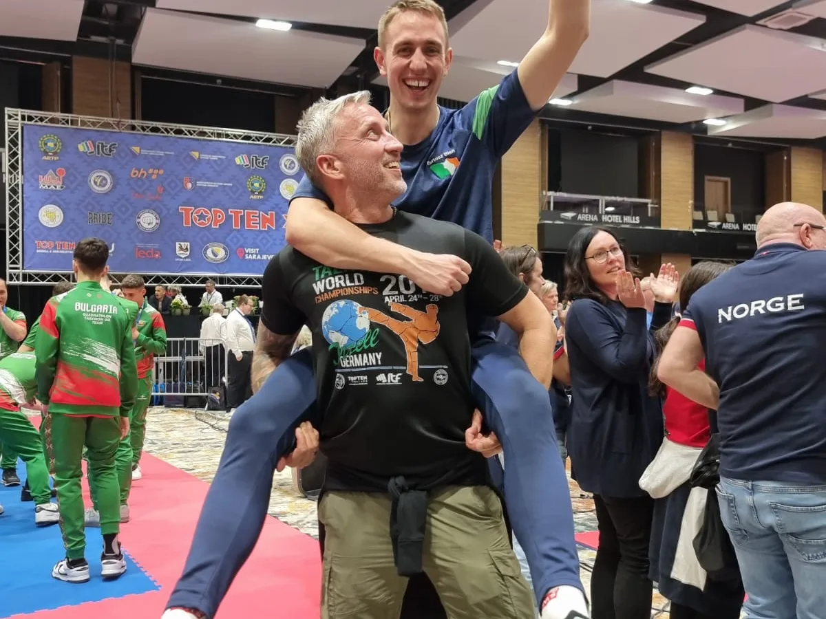 Athlete celebrating a World Championship result with a coach